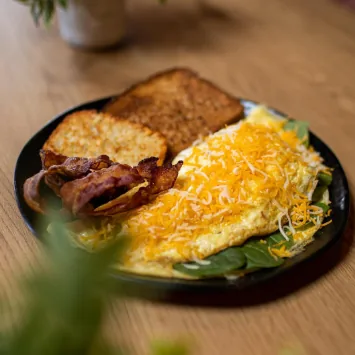 Omelette con tostada y tocineta