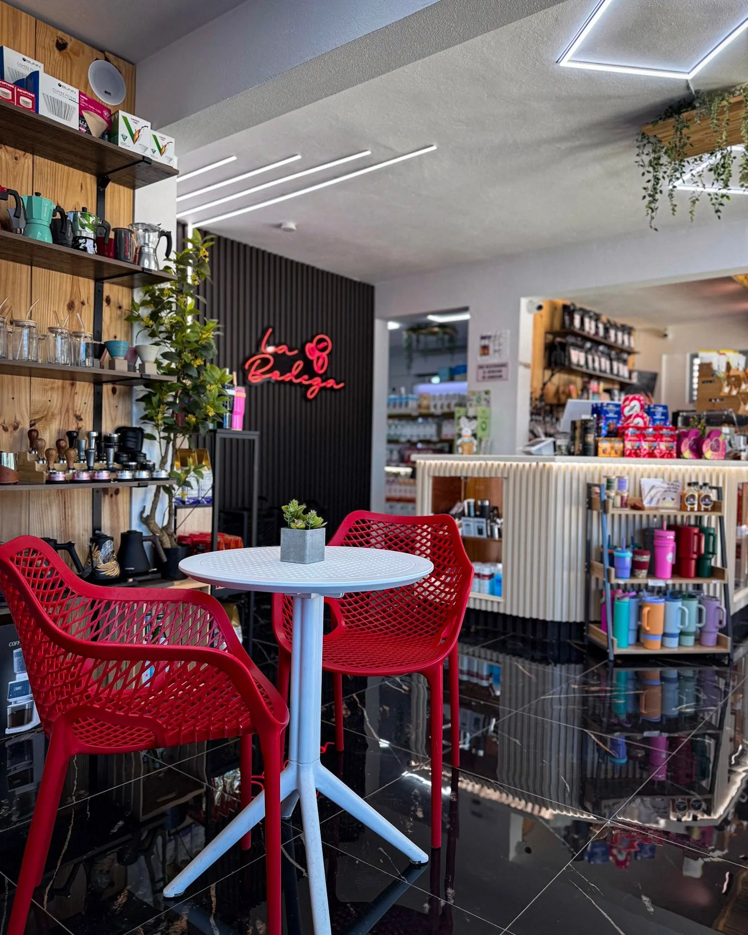 El interior de La Bodega de O Positivo con sus mesas rojas y el letrero de neón
